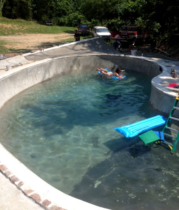 My girlfriend Anna sunbathing as we finish the first pour of the summer.  Notice T-Mo's unfinished graffiti post on the top left of the pool. That guy is cut for life.   