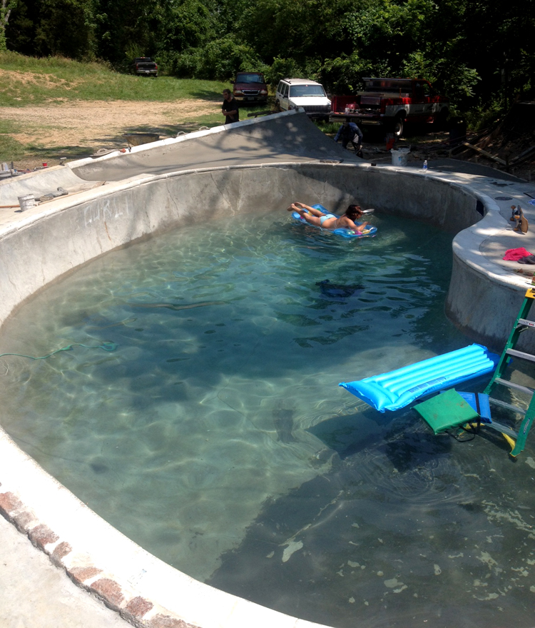 My girlfriend Anna sunbathing as we finish the first pour of the summer. Notice T-Mo's unfinished graffiti post on the top left of the pool. That guy is cut for life.