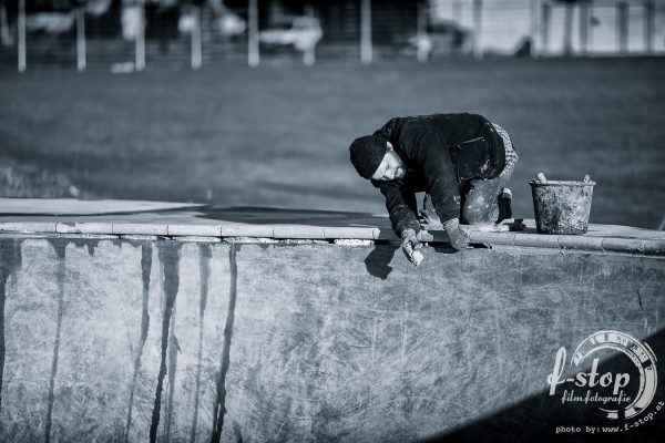 Ratman laying down pool coping.